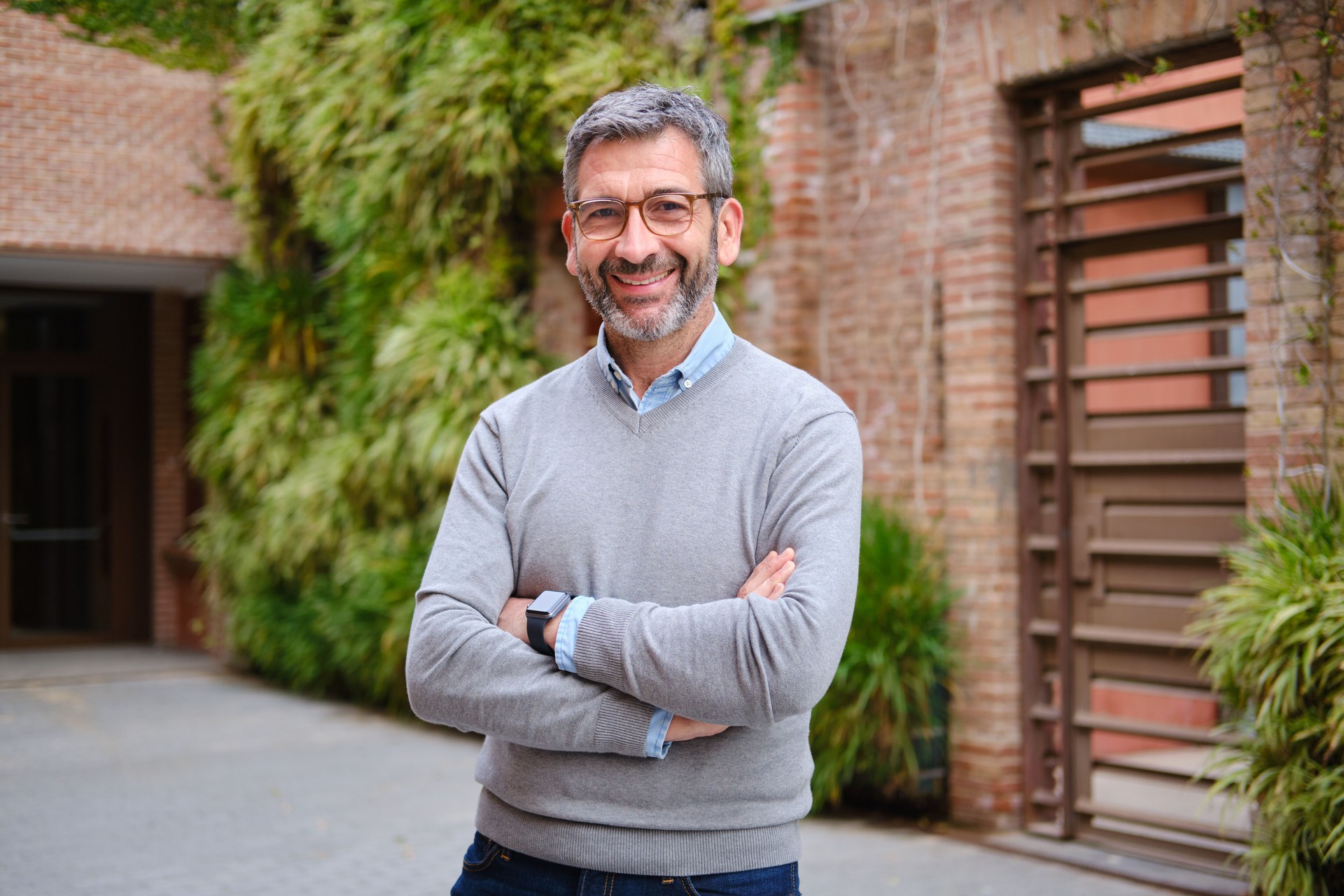 Smiling businessman with folded arms posing in barcelona city
